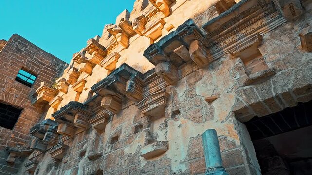 Aspendos Ancient Theatre building details in Antalya, Turkiye, reveal ancient stone textures with a smooth camera movement from right to left.