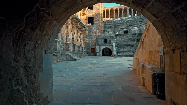 Aspendos, Antalya features a dynamic camera shot moving forward through the monumental arched gateway into the ancient theater.