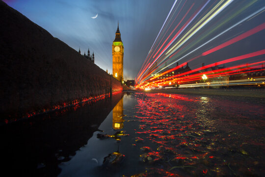 Low angle view of light trails across Westminster Bridge with Big Ben in the distance on a wet night, London, England, UK