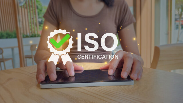 ISO certification conceptual stock photo with digital overlay of ribbon badge and green checkmark