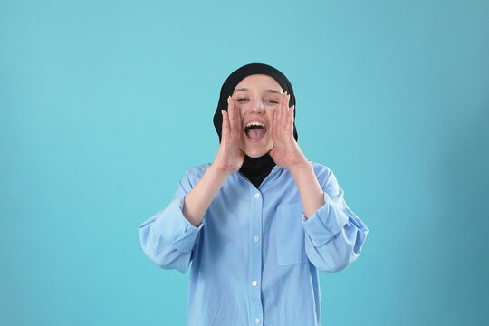 Young Muslim Woman Shouting with Hands Near Mouth
