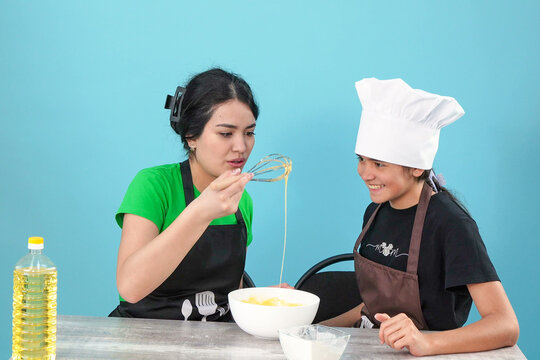 Young Women Baking and Mixing Batter in Kitchen