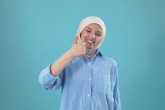 Smiling Young Muslim Woman in Hijab Showing Thumbs Up