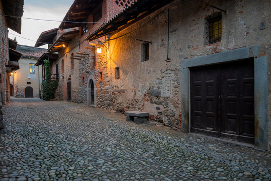 Italia, Ricetto di Candelo. Panorama di borgo medievale imagine fotografata al tramonto con accese le prime luci notturne. Storia e cultura di Italia e d'Europa.