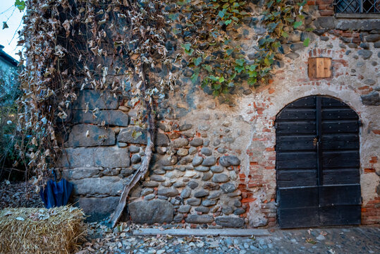 Italia, Ricetto di Candelo. Panorama di borgo medievale. Storia e cultura di Italia e d'Europa. Porta in legno isolata in primo piano.