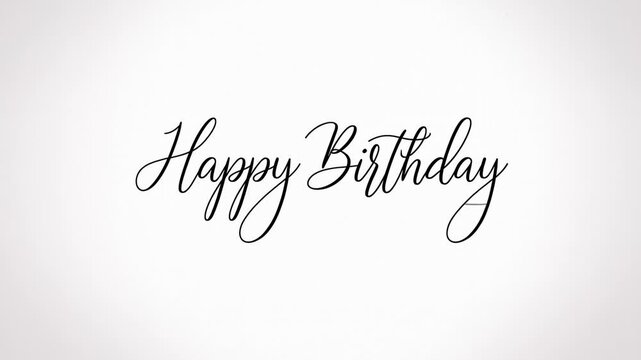 Static shot of calligraphy text appearing on white paper as happy birthday script forms across center of page in studio