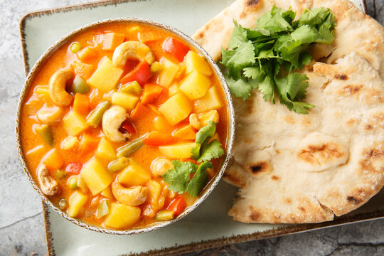 Creamy vegetable vegan korma featuring vibrant vegetables closeup on the bowl on the table. Horizontal top view from above