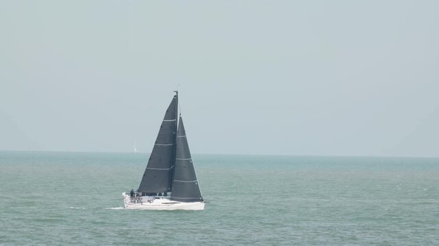 Two sailing yachts with black sails on the open sea slow motion a trip around the world