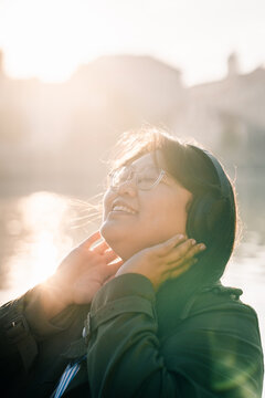 Asian female tourist enjoys music river Prague during sunny weather