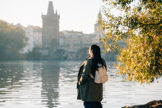 Asian female tourist enjoys view of Prague's architecture river