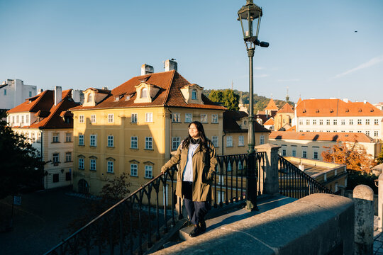 Korean tourist in Prague overlooking the cityscape from bridge