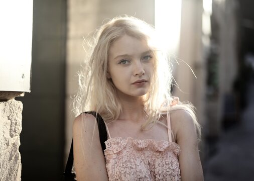Young blonde woman backlit by golden hour sunlight