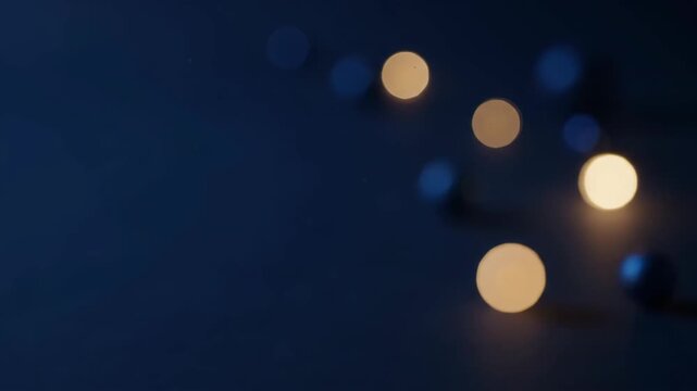 Sparse amber bokeh circles trace a diagonal across the right half of a midnight navy field, set against broad unlit blue space on the left for winter announcements and atmospheric festive design