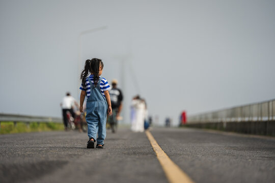 preschool child girl walking on a road on mountain in the morning