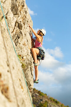 Girls climbing a rock face outdoors as part of women empowerment