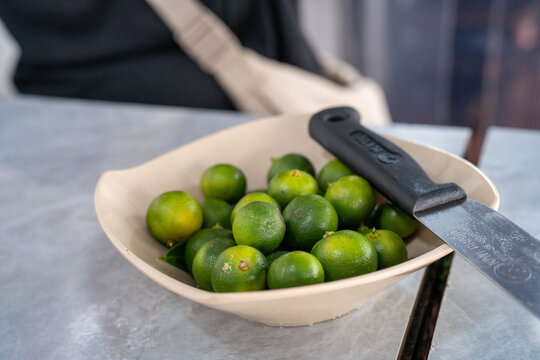 A bowl of fresh green limes ready for cooking or garnishing.