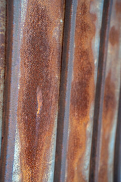 Close-up of rusty metal surface with textured patterns and warm earthy tones.