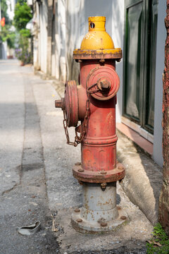 Close-up of a vibrant red and yellow fire hydrant on an urban street.