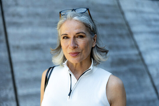 A confident businesswoman poses outdoors in the city