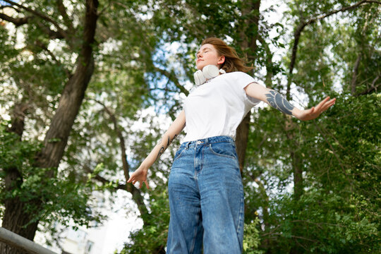 Woman relaxing outdoors in nature with arms outstretched
