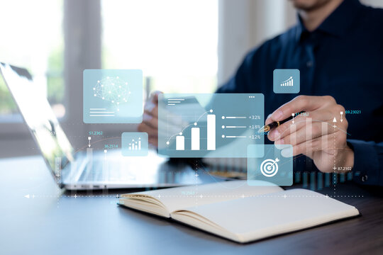 Business analytics concept with growth charts, performance metrics and an AI brain icon as a professional reviews data and plans goals at a desk.