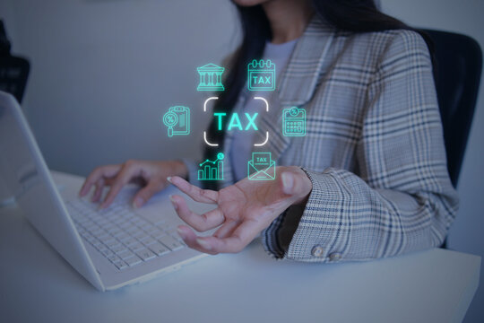 Businesswoman Presenting Hologram Tax Document Icons Over Open Hand while Working on Laptop