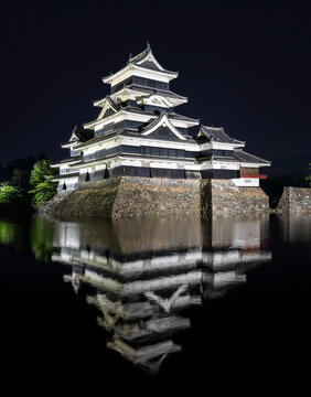 Night view of Matsumoto Castle reflecting in the water, Japan