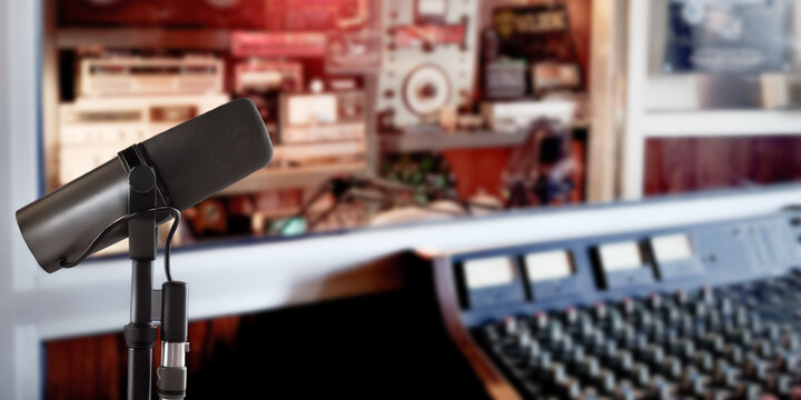 Vocal microphone with radio station studio background and copy space for website banner