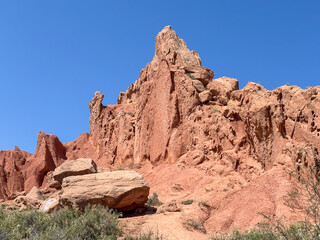 Tall red sandstone pinnacle against blue sky in Skazka (Fairy Tale) Canyon, Kyrgyzstan © Renderville