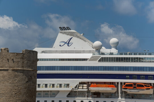 Rhodes - Greece June 01, 2026: Funnel bearing a stylized letter A logo atop the upper decks and radar domes of an Astoria Grande cruise ship in Rhodes, Greece.