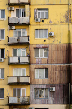 Weathered old panel building facade with corrugated metal wall cladding against rain and mold, Batumi poverty, dampness and poor-quality housing stock exacerbated by high humidity climate in Georgia.