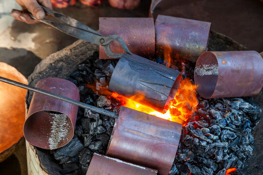 Copper cylinders heated over glowing charcoal with tongs, Jammu and Kashmir, Srinagar, India