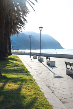 Riva Trigoso seaside promenade benches Italy. Autumn wellness relaxation peaceful morning light. Mediterranean travel destination coastal guide.