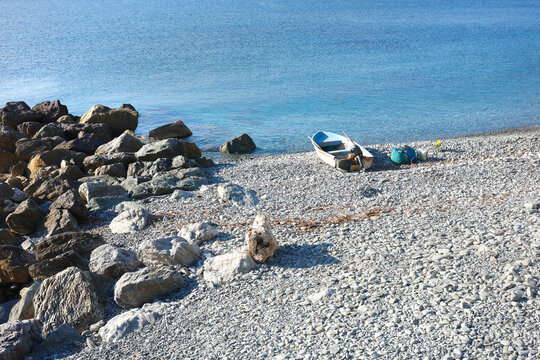 Fishing boat pebble beach Riva Trigoso Italy. Autumn serenity coastal lifestyle sea tranquility. Mediterranean travel destination maritime story guide.