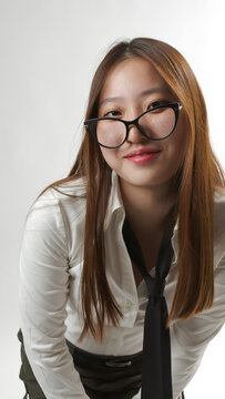 Smiling Young Asian Woman in Glasses and White Shirt Leaning Forward