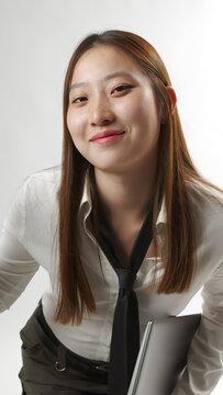 Smiling Young Asian Woman Holding Closed Laptop in White Shirt and Tie