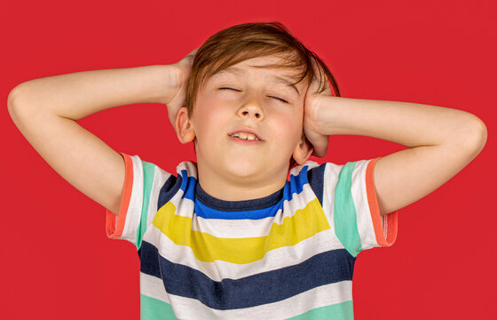 Little boy having a headache, pain. Migraine pain suffering from vertigo or sick, holding head with hand, health problem of brain