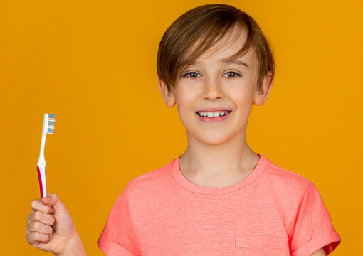 Boy toothbrush white toothpaste. Health care, dental hygiene. Joyful child shows toothbrushes. Little boy cleaning teeth