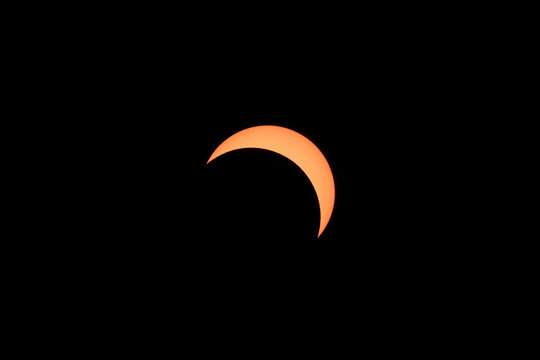 Solar eclipse showing crescent sun silhouette in dark sky