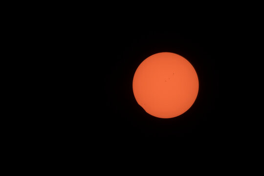 Partial solar eclipse with sunspots in the sky
