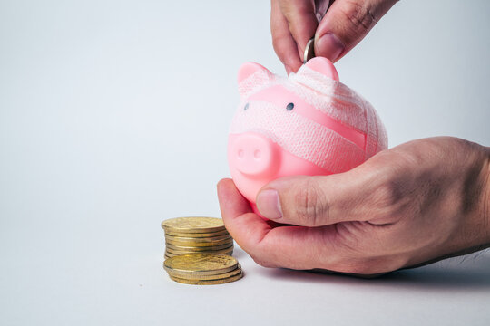 Piggy bank wrapped in a bandage on a plain background with copy space, representing financial recovery, debt relief, deposit protection, bankruptcy, business rehabilitation and a fresh start.
