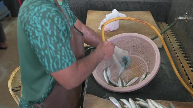 Fish Vendor Cutting Fish for Customer at Mutrah Fish Market, Oman . High Quality premium 4K video footage.