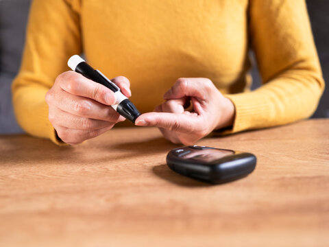Woman pricking finger for blood glucose testing