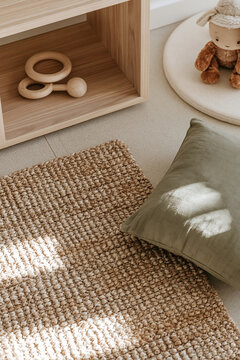 Cozy childrens room corner with woven rug, wooden toy and sage cushion