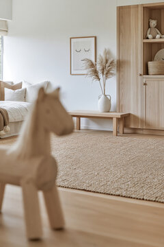 Blurred wooden toy horse overlooking rug and oak furniture in a calm children's room
