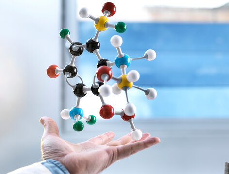 Hand and a floating molecular model, gravity