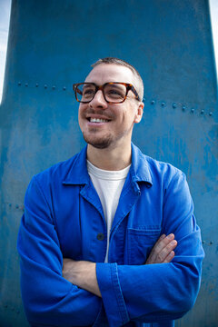 Happy man in a blue jacket stands by a ship rudder in London