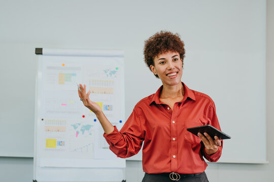 Smiling businesswoman gives strategy presentation in office