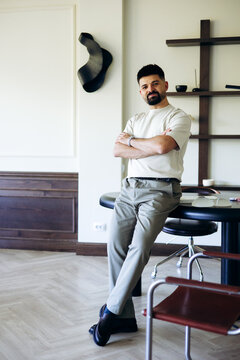 Confident male doctor or surgeon standing with crossed arms in a stylish medical office, showcasing professionalism and expertise