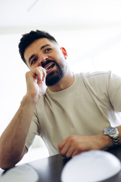 Man with beard carefully brushing his teeth in the bathroom, maintaining good oral hygiene as part of a healthy lifestyle